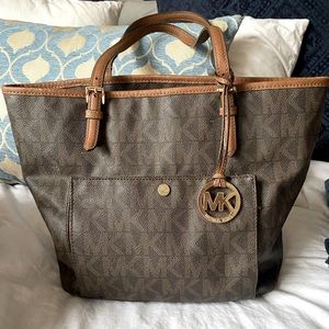 Tote Michael Kors bag, brown and gold emblem.